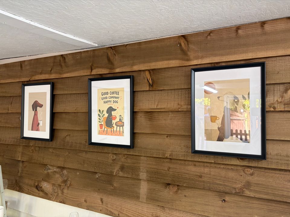 Three framed dog prints on the lodge's timber wall